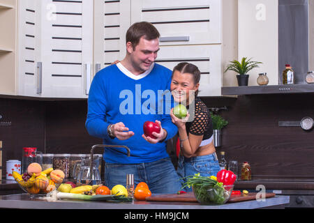 Schöne junge Paar zusammen in der Küche zu essen Apfel Stockfoto