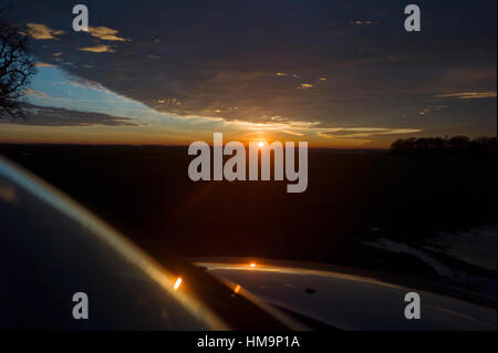 Debden North Essex, England UK. Mit der Temperatur bei Null die Sonnenuntergänge in eine Makrele Himmel und spiegelt sich in gefrorenem Eis Wasser. 18. Januar 2017 Stockfoto