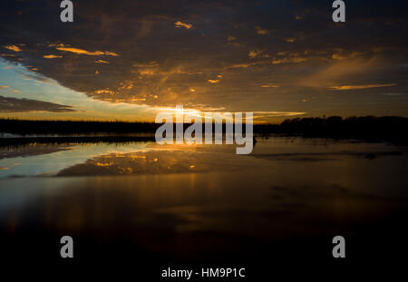 Debden North Essex, England UK. Mit der Temperatur bei Null die Sonnenuntergänge in eine Makrele Himmel und spiegelt sich in gefrorenem Eis Wasser. 18. Januar 2017 Stockfoto