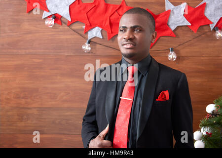 Afrikanischer Mann posiert vor Weihnachten Hintergrund. Stockfoto