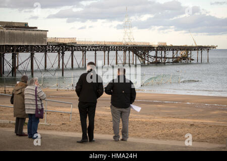 Besucher auf Cowlyn Bay auf der Suche nach Ansicht Teile von Victoria Pier ins Meer während des Tages mit mehr erwartet gefallen Stockfoto