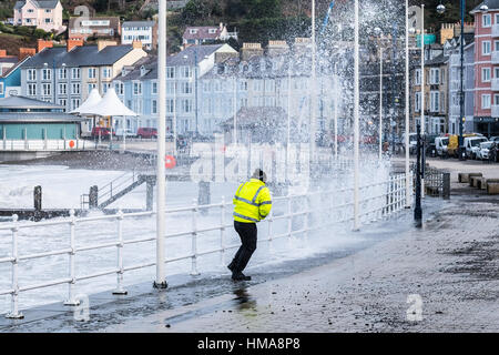 Aberystwyth, Wales, UK. 2. Februar 2017. Als Sturm Doris Ansätze eine Jacke weicht in einem hi-Vis eine Wellen brechen über Aberystwyth Promenade Credit: Alan Hale/Alamy Live News Stockfoto