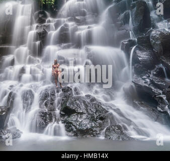 Frau im Wasserfall, Luft Terjun Kanto Lampo, in der Nähe von Ubud, Bali, Indonesien Stockfoto