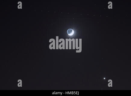 Halbmond helle und dunkle Seiten, helle Venus und einem vorbeifahrenden Flugzeug Stockfoto