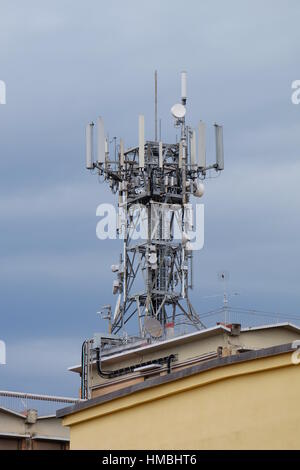 Handy-Antenne auf dem Dach eines Gebäudes - sparen auf Eigentumswohnung Gebühren - Eigentumswohnung-Serie - schädliche Handy-Turm gegen einen grauen Himmel Stockfoto