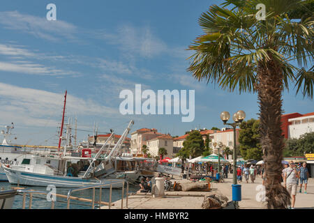 POREC, Kroatien - 14. September 2014: Unkenntlich Menschen spazieren am Meer mit festgemachten Schiffe. Fast 2.000 Jahre alten Porec ist, eine Stadt und Gemeinde Stockfoto