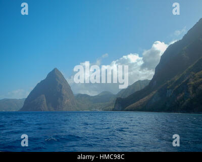 Petit und Gros Pitons und Meer im Petit und Gros Pitons und See in St. Lucia aus dem Süden an einem sonnigen Tag mit blauem Himmel und weißen Blätterteig Wolken Stockfoto