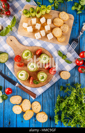 Draufsicht der Brot Zwieback gekrönt mit einem Würfel von Feta-Käse und Gurken Scheiben Stockfoto