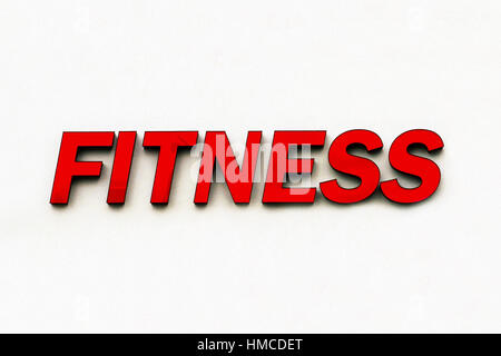Roter Kunststoff Zeichen des Wortes "Fitness" wirbt ein Gymnasium und isoliert auf eine weiße Wand Hintergrund. Stockfoto