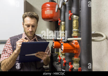 Klempner, die Wartung von einem Brennwertkessel durchführt Stockfoto