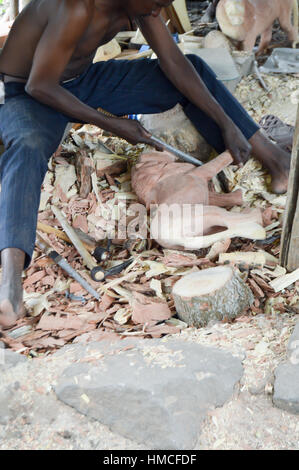 Kenianische Handwerker schnitzen zwei Löwen mit rosa Holz in einer Genossenschaft in Mombasa Stockfoto