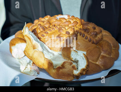 Mann, gekleidet in Jacke hält eine üppige leckere Brot Stockfoto