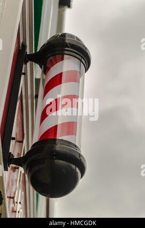 Barbiere Pole gegen eine bewölkt/Grau Himmel mit Textfreiraum. Stockfoto