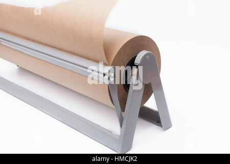 Rolle des braunen Kraftpapier und Papierschneider auf weißem Hintergrund Stockfoto