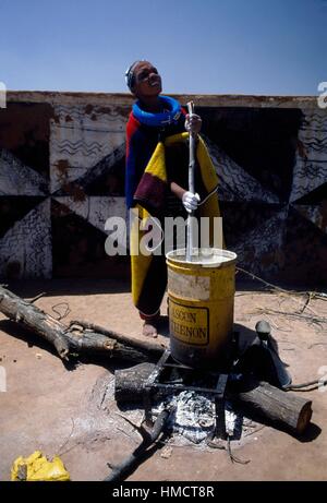 Ndebele Frau Malerei Wandmalereien im Dorf Botshabelo Township, Transvaal, Südafrika Farben vorbereiten. Stockfoto