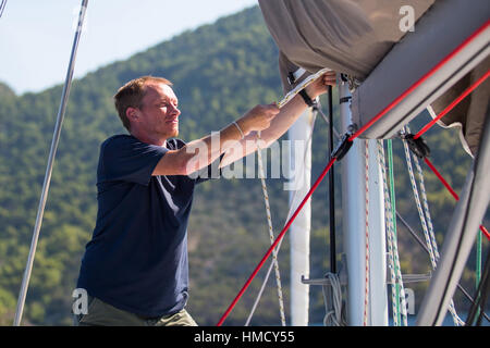 Skipper strafft die Seile auf seiner Segelyacht. Stockfoto