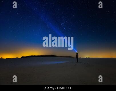 Night Sky Beobachter. Mann mit Kopf Taschenlampe zeigt Licht am Sternenhimmel. Nachtlandschaft Stockfoto