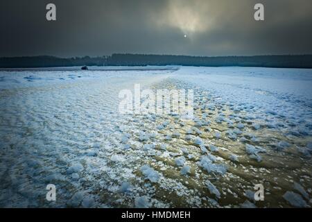 Herrliche Winterlandschaft mit Eisstruktur. Gefrorenes Wasser-Reservoir auf Feldern. Eisstruktur. Stockfoto
