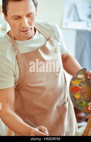 Überglücklich Mann mit Palette und Pinsel Stockfoto