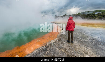 Frau stand am Rand der Champagne Pool, Sprudel, Waiotapu geothermische Wunderland, Rotorua, Nordinsel, Neuseeland Stockfoto