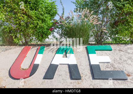 VAE-Nationalflagge-Denkmal in einem Kreisverkehr in Liwa-Oase Stockfoto