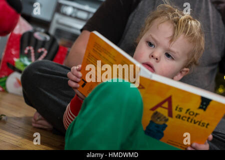 Denver, Colorado - Adam Hjermstad Jr., 2 1/2, liest ein Buch, A steht für Aktivist, die er zu Weihnachten geschenkt wurde. Stockfoto