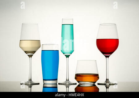 Bild der Hintergrundbeleuchtung Getränke in verschiedenen alkoholischen Gläser auf reflektierenden Tisch Stockfoto