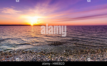 Steinen am Strand bei Sonnenuntergang auf dem Meer. Landschaftsfoto von Sonnenaufgang oder Sonnenuntergang am Naturstrand in Piran, Slowenien. Stockfoto