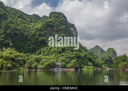 Landschaft auf Wasser und Berge mit einer Pagode und Zeile Boote entlang des Flusses in Vietnams Trang eine malerische Landschaft. Stockfoto