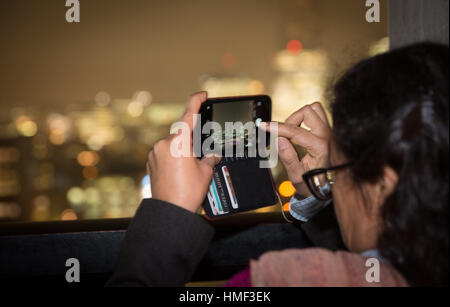 Eine Frau nimmt ein Foto vom Balkon des Tate Modern Schalter House in London Stockfoto