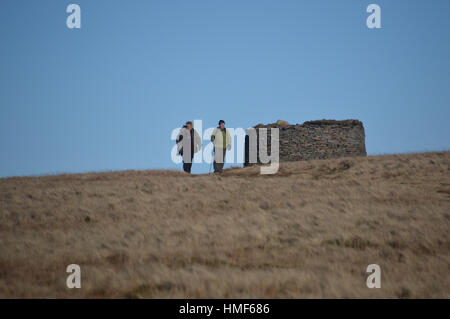 Zwei ältere Fellwalkers, die zu Fuß vom trockenen Stein Shelter auf Pendle Hill. Lancashire England UK. Stockfoto