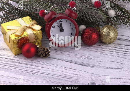 Weihnachten-Weihnachten-Neujahr Urlaub Dekoration mit Geschenk Box rot Wecker Kegel natürliche Tanne Äste golden Ball auf weißem Hintergrund aus Holz, Nahaufnahme Stockfoto