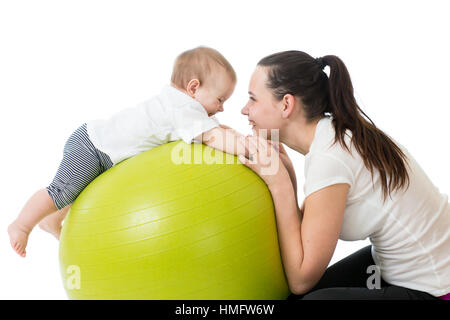 junge Mutter und ihr Baby Yoga Übungen auf Gymnastik Ball isoliert auf weiß Stockfoto