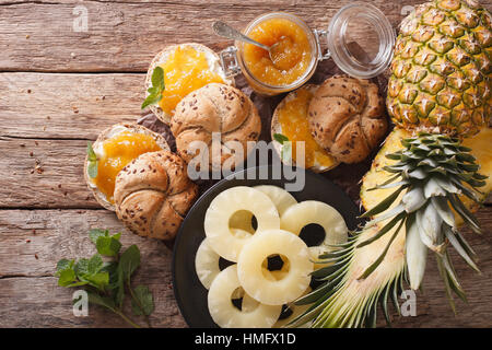 Hausgemachte Ananas Marmelade und süße Brötchen auf dem Tisch. horizontale Ansicht von oben Stockfoto