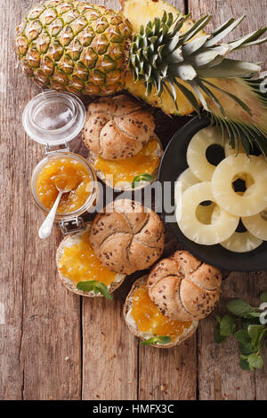 Hausgemachte Ananas Marmelade und süße Brötchen auf dem Tisch. vertikale Ansicht von oben Stockfoto
