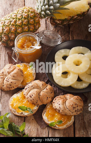 Süße Brötchen mit Ananas Marmelade und Butter Nahaufnahme auf dem Tisch. Vertikal Stockfoto