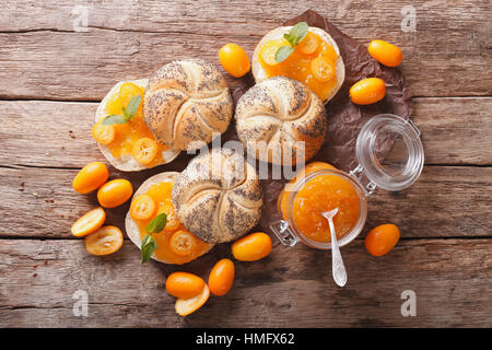 Süße Brötchen mit hausgemachten Kumquat-Marmelade-Nahaufnahme auf dem Tisch. horizontale Ansicht von oben Stockfoto