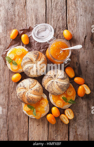 Süße Brötchen mit hausgemachten Kumquat-Marmelade-Nahaufnahme auf dem Tisch. vertikale Ansicht von oben Stockfoto