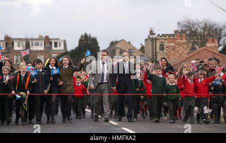 Lokalen MP Nigel Adams (links), Gemeinschaften Sekretär Sajid Javid und lokalen Schulkindern an der wiedereröffneten Tadcaster Brücke mehr als ein Jahr nach seiner teilweisen Zusammenbruch kam um die Zerstörung der 2015 Weihnachten Überschwemmungen zu symbolisieren. Stockfoto