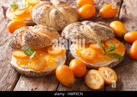 Süße Brötchen mit Kumquat-Marmelade und Frischkäse-Nahaufnahme auf dem Tisch. horizontale Stockfoto