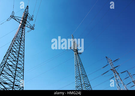 großen Hochspannung elektrische Türme unter blauem Himmel Stockfoto