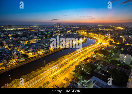 Bunte Nacht Stadt mit Wolken am Tau Hu-Kanal und die Ost-West-Autobahn (Vo Van Kiet Street) in Ho-Chi-Minh-Stadt (Saigon). Blick vom Dach des Builds Stockfoto