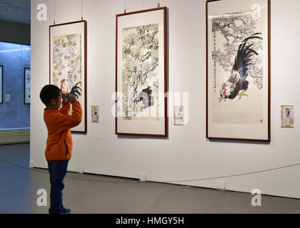 Taiyuan, China Shanxi Provinz. 3. Februar 2017. Ein Kind nimmt Foto eines Stückes von Hahn-Themen Malerarbeiten in einer Galerie in Taiyuan, Hauptstadt der Provinz Nord-China Shanxi, 3. Februar 2017. Chinesische Leute feierten das Mondjahr von "Hahn" am 28. Januar. Bildnachweis: Cao Yang/Xinhua/Alamy Live-Nachrichten Stockfoto