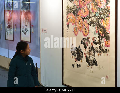 Taiyuan, China Shanxi Provinz. 3. Februar 2017. Ein Kind sieht ein Stück von Hahn-Themen Malerarbeiten in einer Galerie in Taiyuan, Hauptstadt der Provinz Nord-China Shanxi, 3. Februar 2017. Chinesische Leute feierten das Mondjahr von "Hahn" am 28. Januar. Bildnachweis: Cao Yang/Xinhua/Alamy Live-Nachrichten Stockfoto