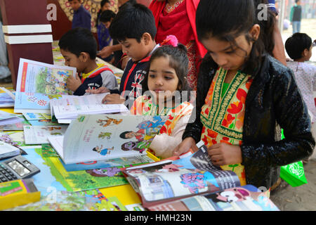 Dhaka, Bangladesch. 3. Februar 2017. Bangladeshi Kind Shopper durchsuchen Bücher in einem Stall während des Landes größte Buchmesse in Dhaka, Bangladesch. Am 3. Februar 2017. Bangladesch die größte Buchmesse begann in Dhaka ab dem 1. Februar mit Polizei Warnung Veranstalter gegen den Verkauf von Büchern, die "religiöse Gefühle" in dem mehrheitlich muslimischen Land verletzt. Der einmonatigen Ekushey Buchmesse zieht Hunderttausende Besucher in die überfüllten Hauptstadt eines Bangladeshs Keynote Kulturveranstaltungen und dem Leser eine Chance, mit den Autoren zu interagieren. Bildnachweis: Mamunur Rashid/Alamy Live-Nachrichten Stockfoto