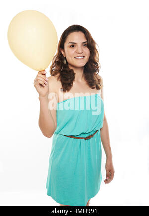 Latino Mädchen mit gelben Ballon isoliert auf weiss Stockfoto