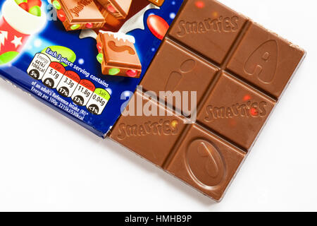 Bar von Nestle Smarties festliche Sharing Block Schokolade geöffnet Inhalt auf weißem Hintergrund zu zeigen - mit Schokolade Quadrate Stockfoto
