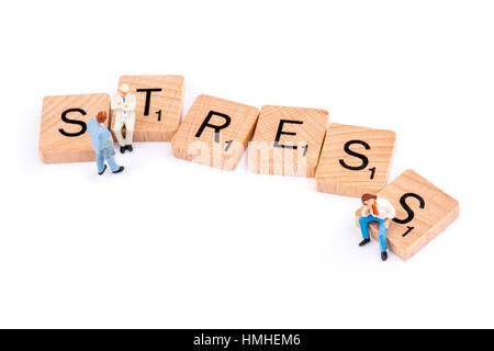 Scrabble Buchstaben bilden das Wort STRESS zwei Zahlen, einen jungen Mann saß auf der Buchstabe s ignorieren Stockfoto