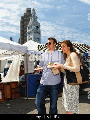 Niedrigen Winkel Ansicht eines Paares in einer Straße Messe mit Essen gehen, San Francisco, Kalifornien Stockfoto