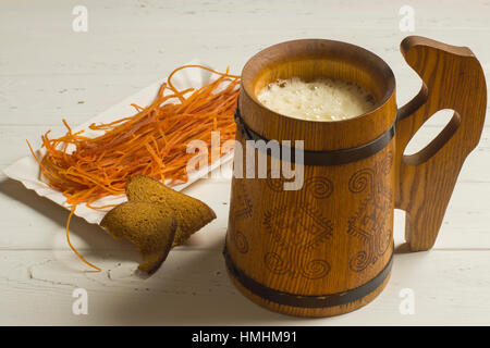 Krug Bier, getrocknete Brot und getrockneten Meeresfrüchten auf weißem Holz Hintergrund Stockfoto
